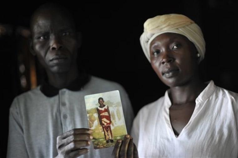 Balluonzima Christ and Rose Ajiba hold a photograph of their child Caroline Aya, who was killed and had her tongue cut out — a sign that she was probably a human sacrifice in a ritual killing in Jinja, Uganda.